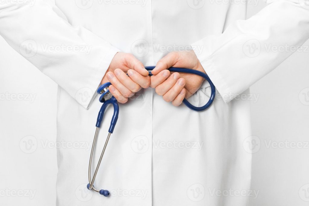 990737 medico segurando estetoscopio atras das costas foto