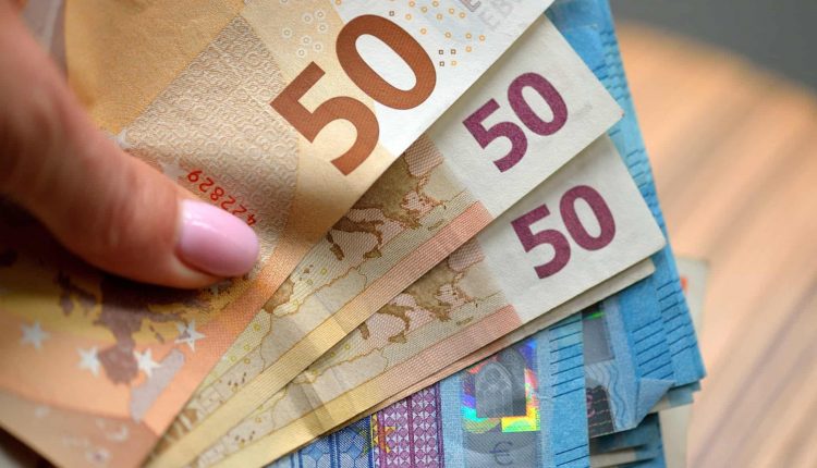 hand holding 50 and 20 euro banknotes money eur currency of european union t20 GJxWK0